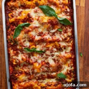 A whole cooked gluten-free lasagna in a tin baking dish topped with fresh basil, ready to be served and enjoyed by the family.