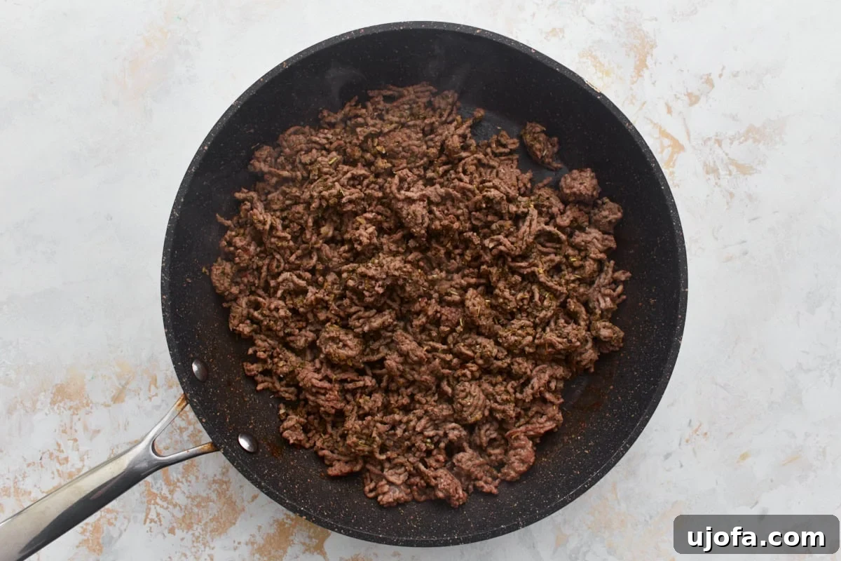 Irresistible Gluten-Free Lasagna 5 Lean ground beef browning in a black skillet with seasoning, ready for the pasta sauce.