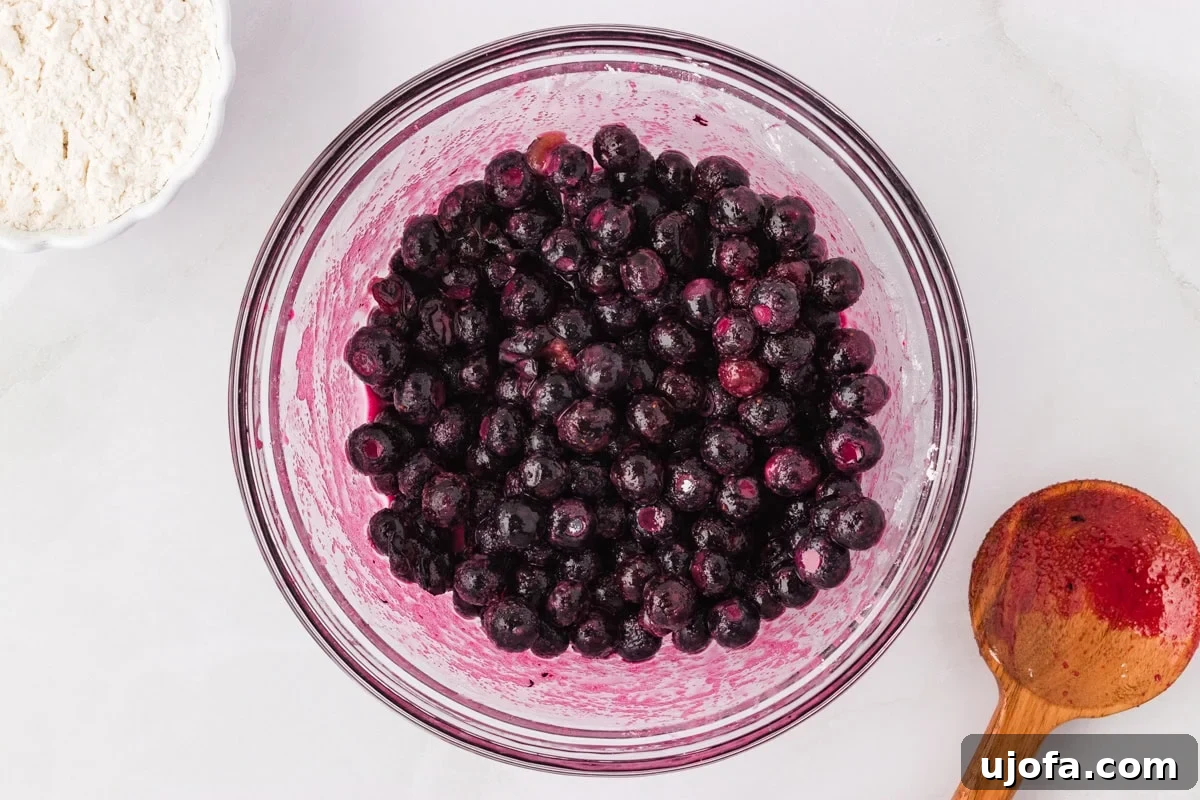 Fresh or frozen blueberries tossed with sugar, lemon juice, and cornstarch in a glass mixing bowl.