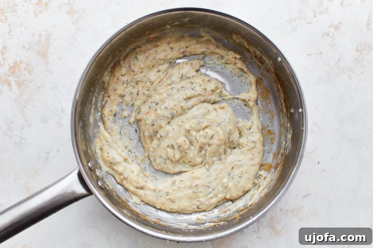 The Ultimate Gluten-Free Chicken Pot Pie 10 slurry mixture of gluten-free flour, milk, herbs, and spices in a stainless steel pot.