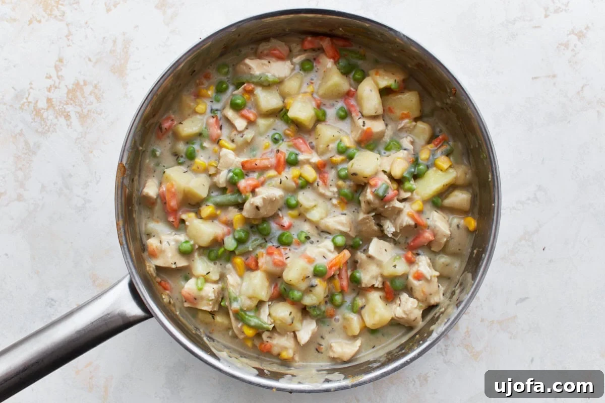The Ultimate Gluten-Free Chicken Pot Pie 12 gluten-free chicken pot pie filling with cream sauce, cooked chicken, mixed vegetables and cubed potatoes in a stainless steel pot