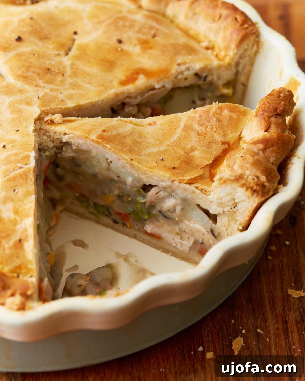 The Ultimate Gluten-Free Chicken Pot Pie 4 slice cut of gluten-free chicken pot pit in white baking dish with remaining pie