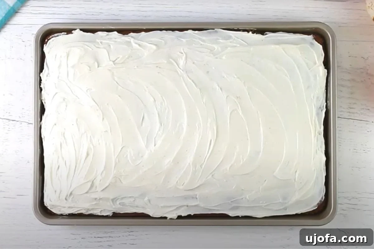 Decadent Gluten-Free Pumpkin Spice Squares 14 A baking sheet is filled with beautifully frosted gluten-free pumpkin bars, each square glistening with creamy white frosting, ready to be served and enjoyed as a delicious fall treat.