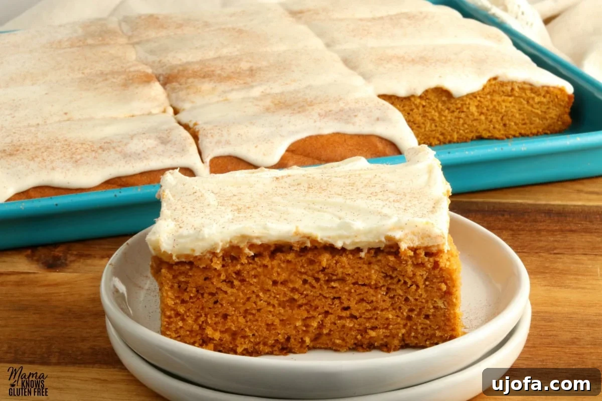 Decadent Gluten-Free Pumpkin Spice Squares 3 A perfectly portioned gluten-free pumpkin bar sits on a small white plate, invitingly frosted. In the background, the full pan of frosted bars hints at more deliciousness to come, ready for serving.