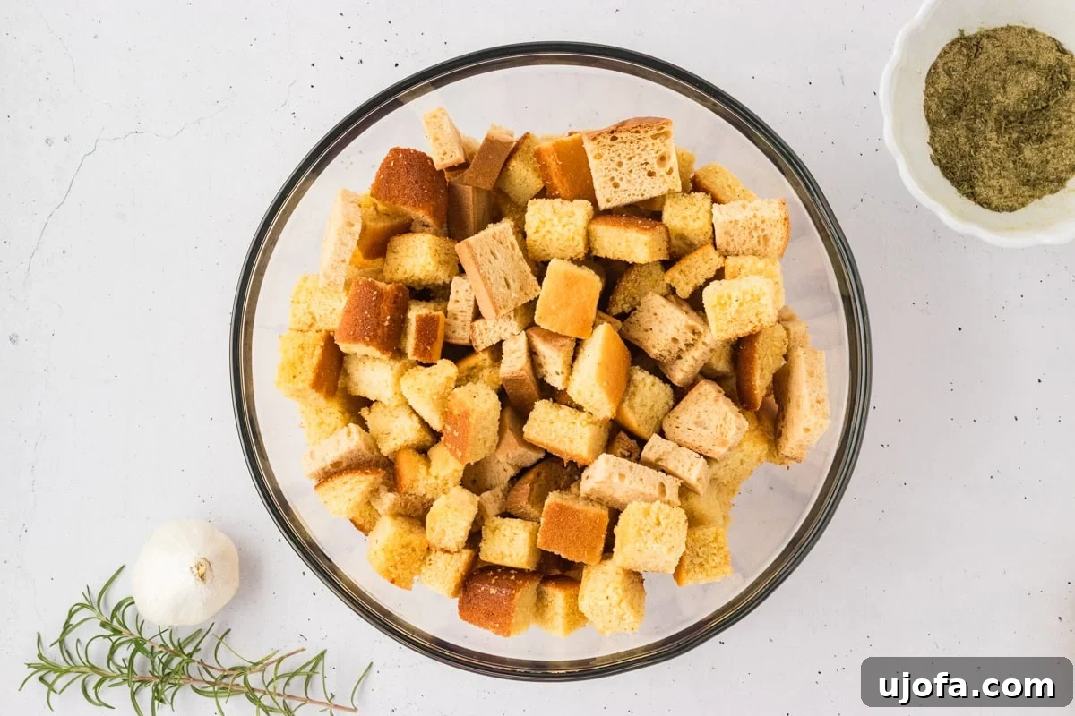 Savory Gluten-Free Cornbread Dressing 12 A large glass bowl holding a mix of cubed gluten-free cornbread and gluten-free bread, prepared for the stuffing mixture.