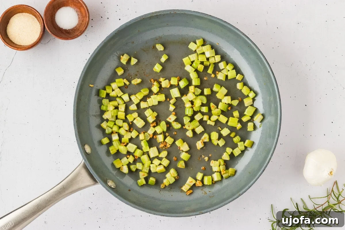 Savory Gluten-Free Cornbread Dressing 13 Diced celery and minced garlic sautéing in a pan with olive oil, creating fragrant aromatics for the stuffing.