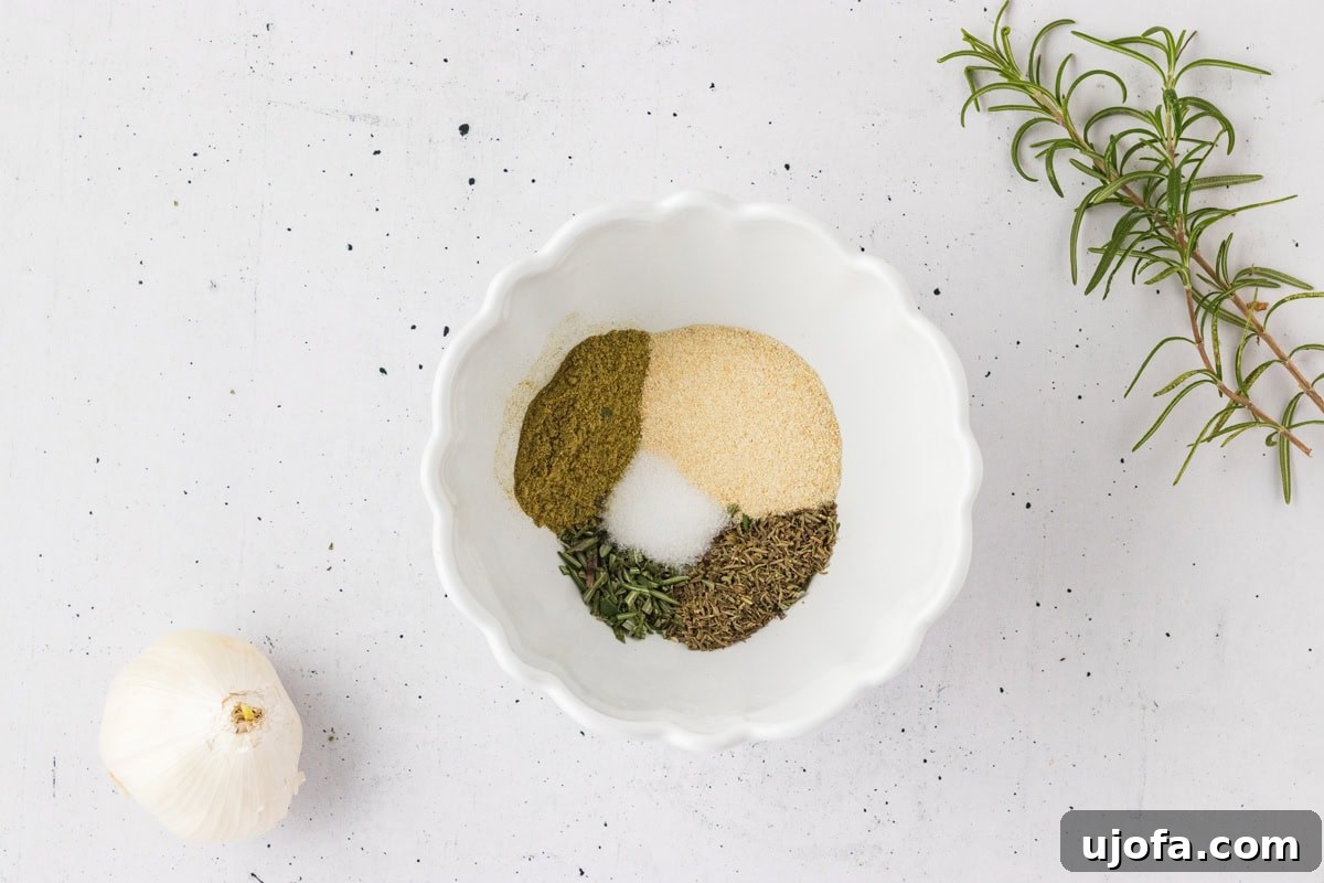 Savory Gluten-Free Cornbread Dressing 14 A white bowl containing a mix of dried herbs and spices for the stuffing, including salt, onion powder, thyme, sage, and rosemary.