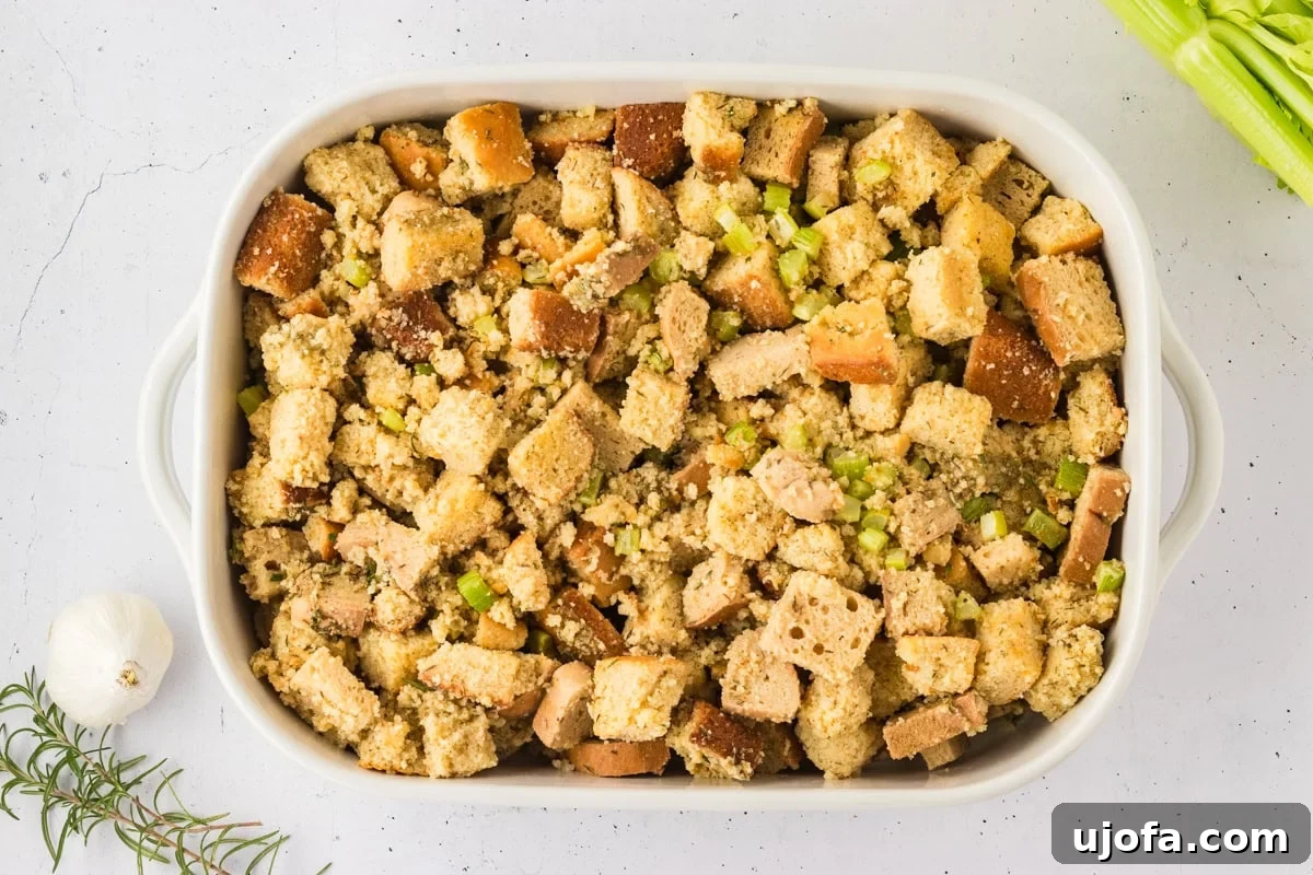 Savory Gluten-Free Cornbread Dressing 17 The combined stuffing mixture of seasoned gluten-free cornbread and gluten-free bread cubes, with sautéed celery and garlic, placed in a white casserole dish, ready to be baked.