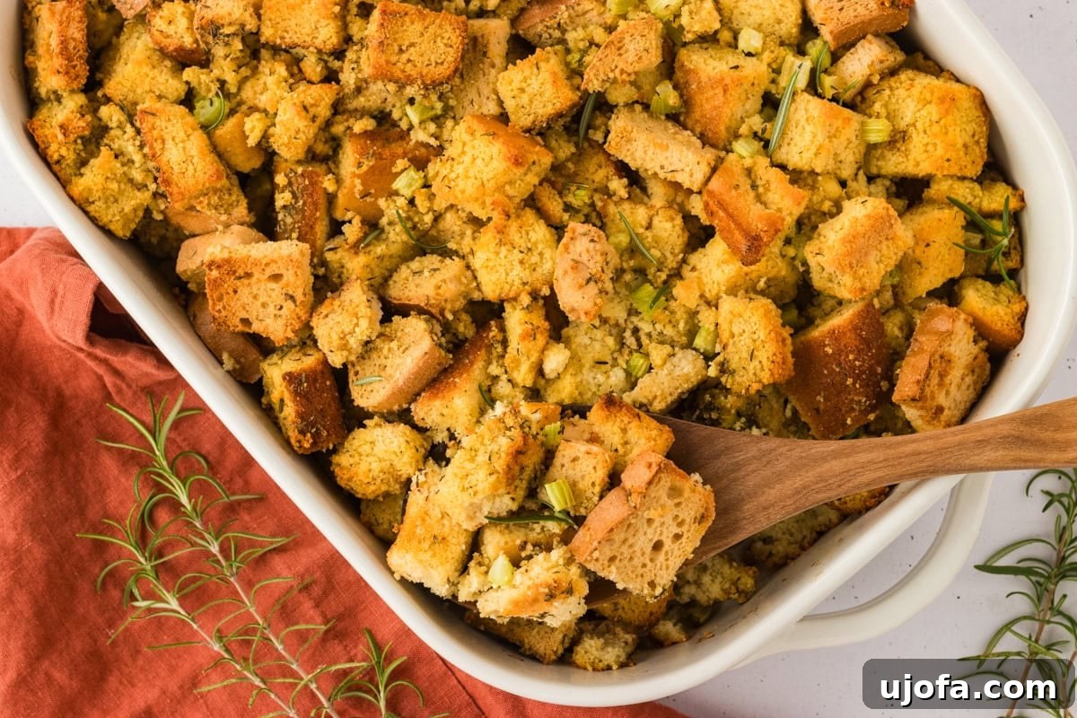 Savory Gluten-Free Cornbread Dressing 19 A wooden spoon scooping out a portion of the baked gluten-free cornbread stuffing, showcasing its moist, fluffy texture and golden-brown crust.