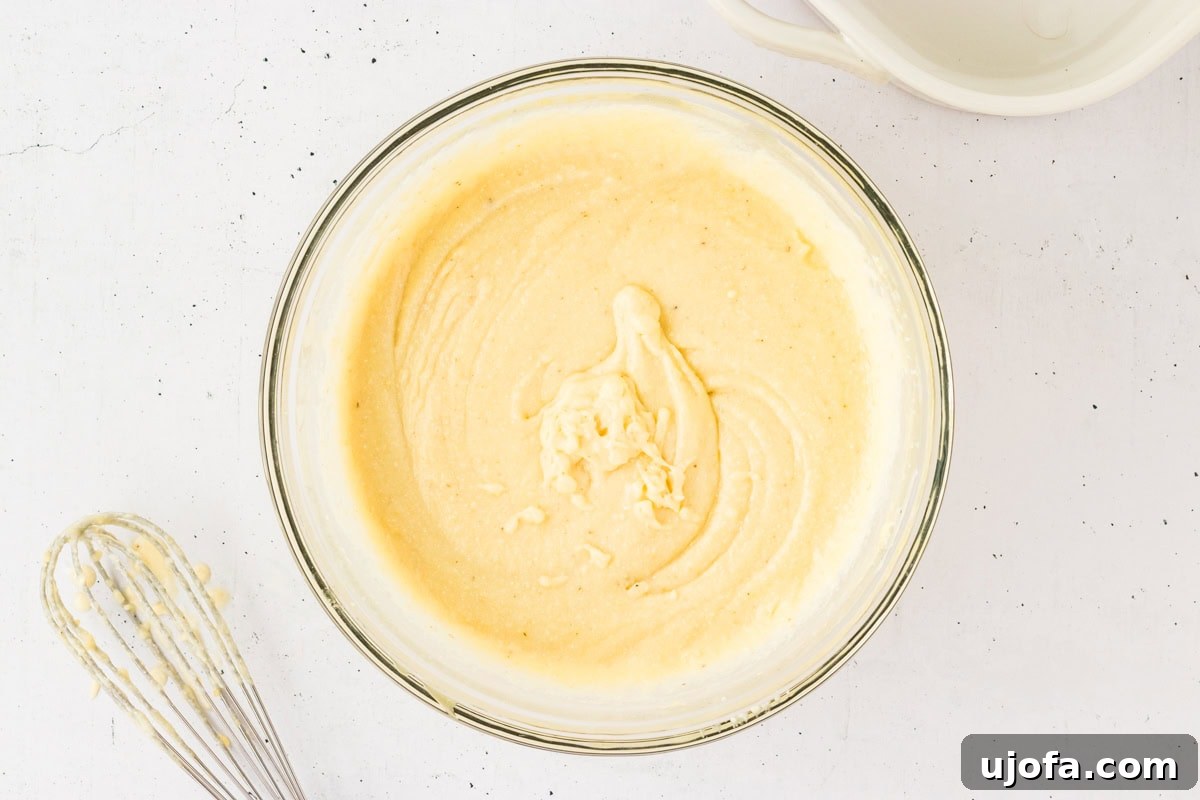 Savory Gluten-Free Cornbread Dressing 8 A smooth and creamy gluten-free cornbread batter in a glass bowl, after all wet ingredients and melted butter have been incorporated.