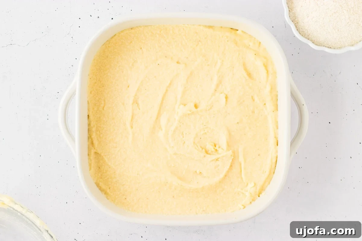 Savory Gluten-Free Cornbread Dressing 9 A casserole dish filled with smooth, spread-out gluten-free cornbread batter, ready to be baked to perfection.