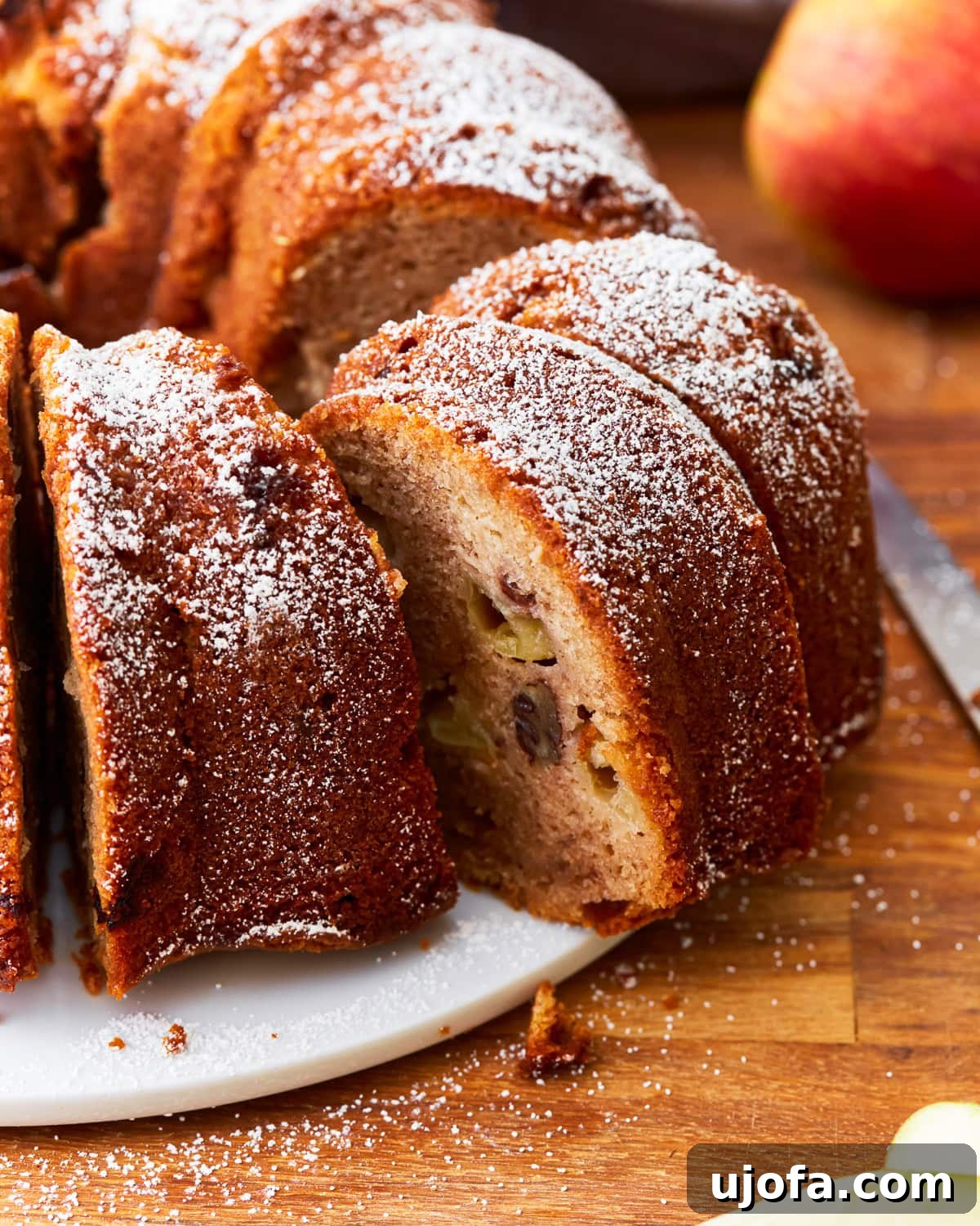 A close-up shot of a perfectly sliced gluten-free apple cake, revealing its moist texture and apple chunks, ready to be served.