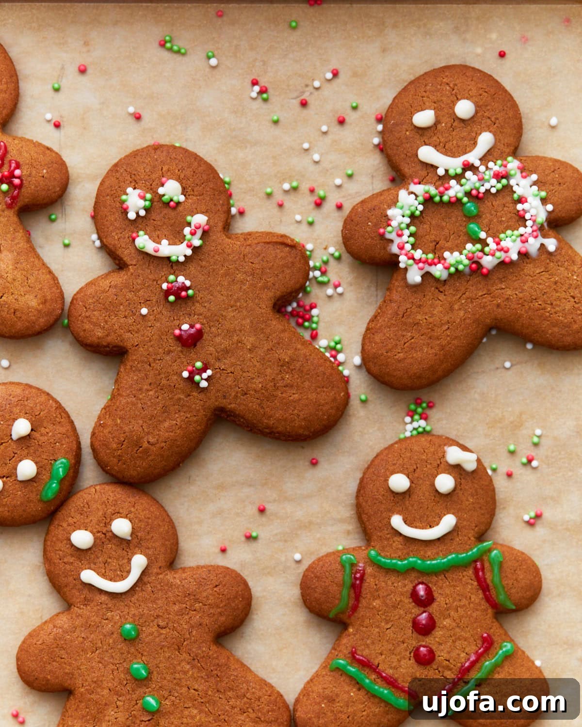 Guilt-Free Gingerbread Bliss 2 A vibrant overhead shot of an array of beautifully decorated gluten-free gingerbread cookies in various holiday shapes, scattered on a white surface, ready for festive enjoyment.
