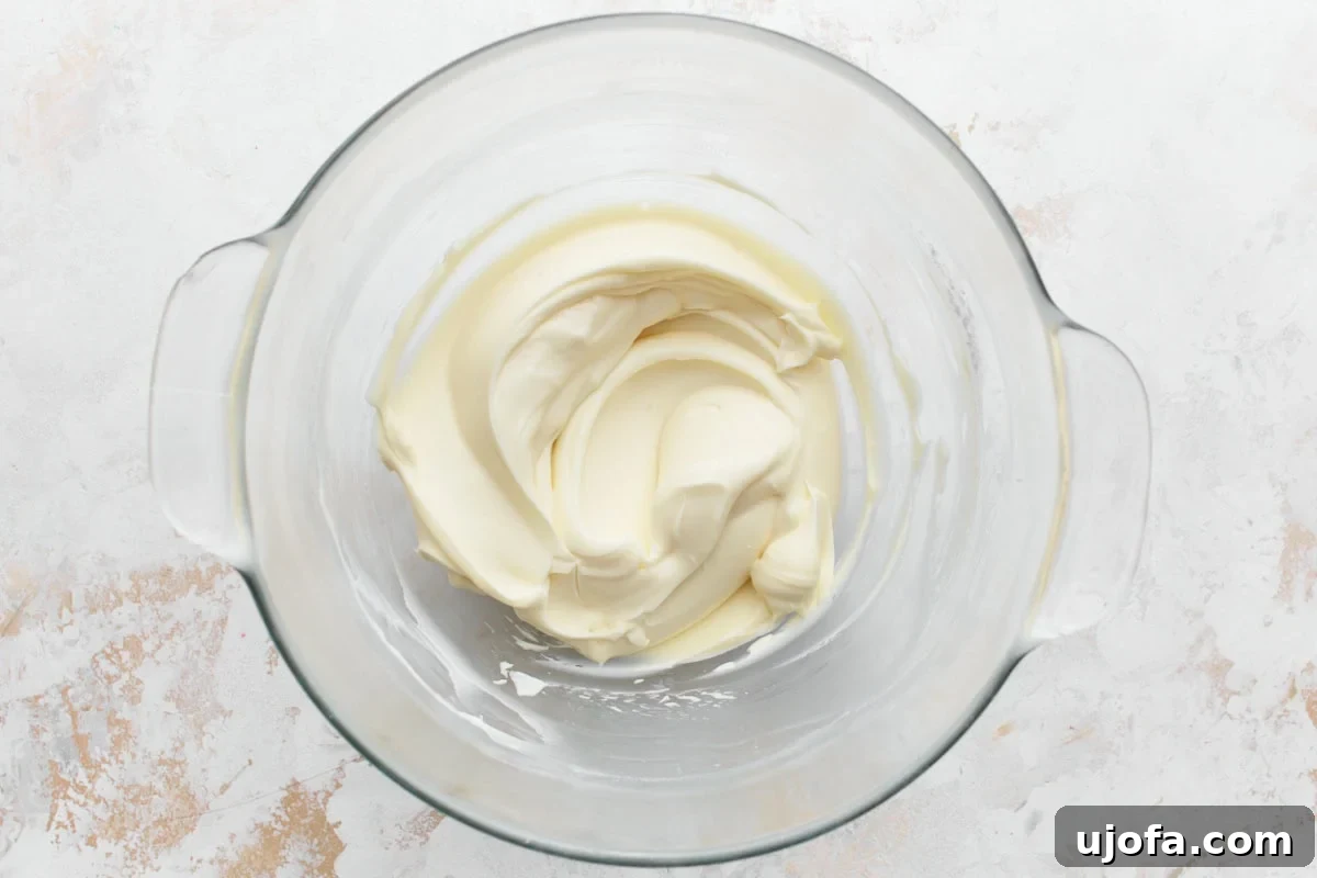 Vanilla cream cheese frosting creamed together in glass mixing bowl, with a velvety smooth texture