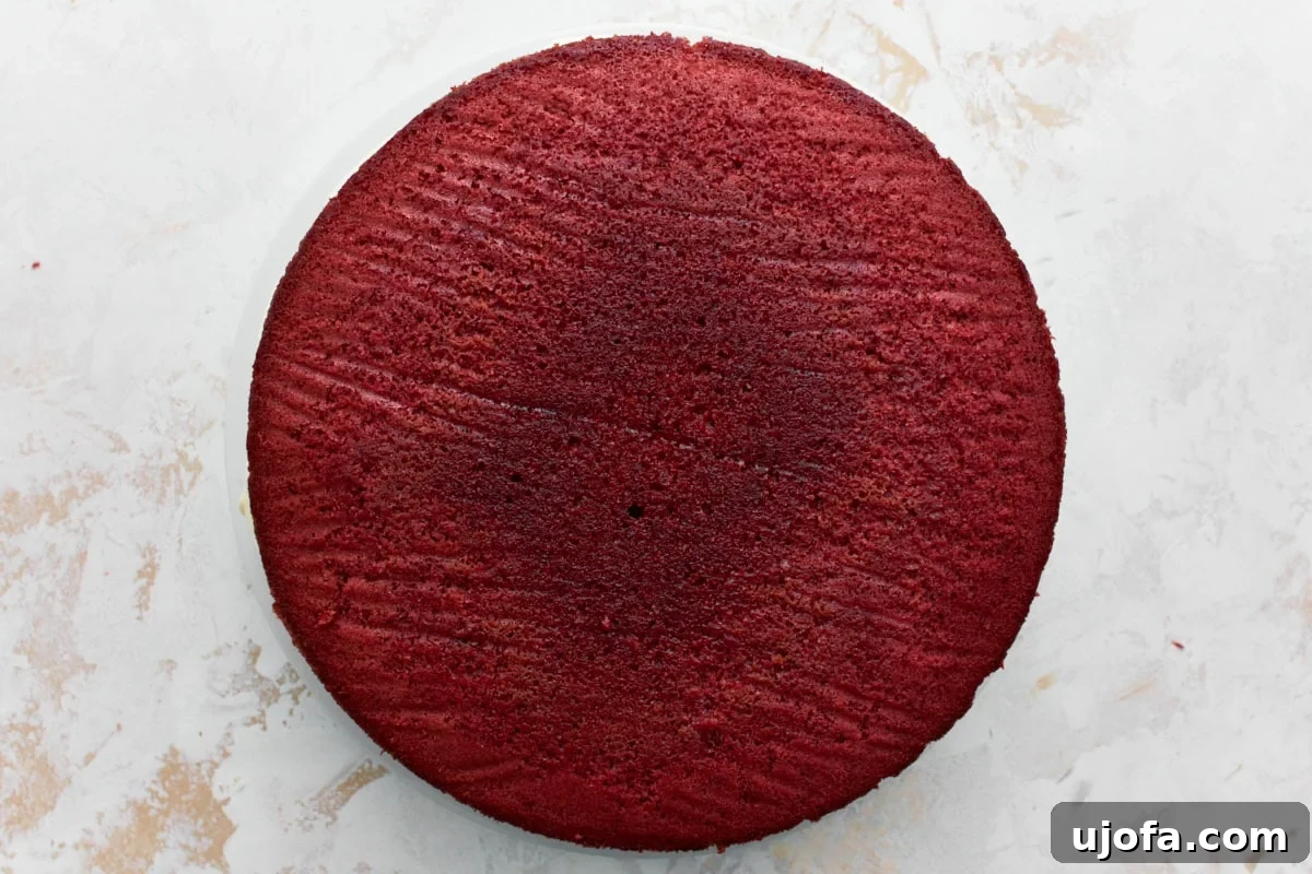 Baked gluten-free red velvet cake on a white cake plate layered 