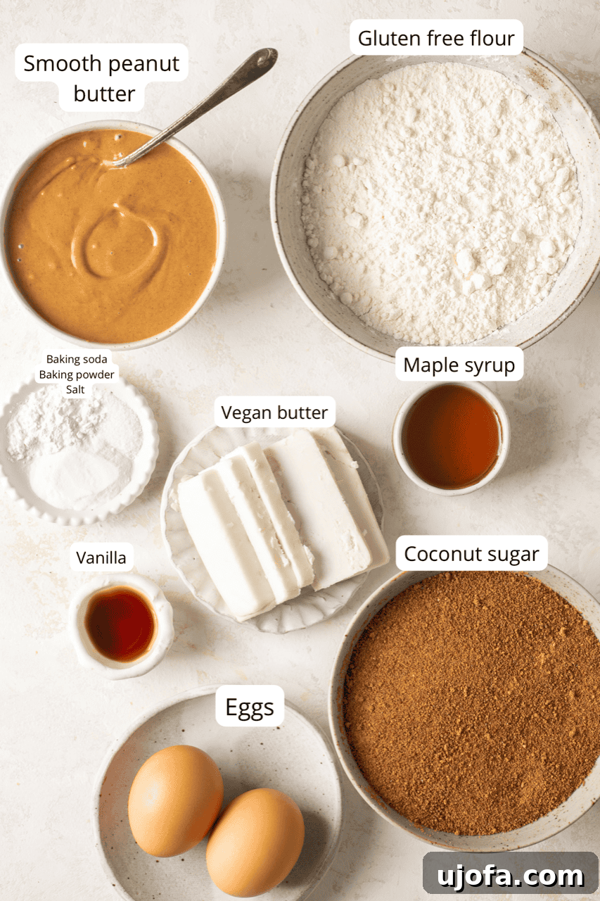 Labeled bowls containing individual recipe ingredients like peanut butter, sugar, flour, and butter, neatly arranged for baking.