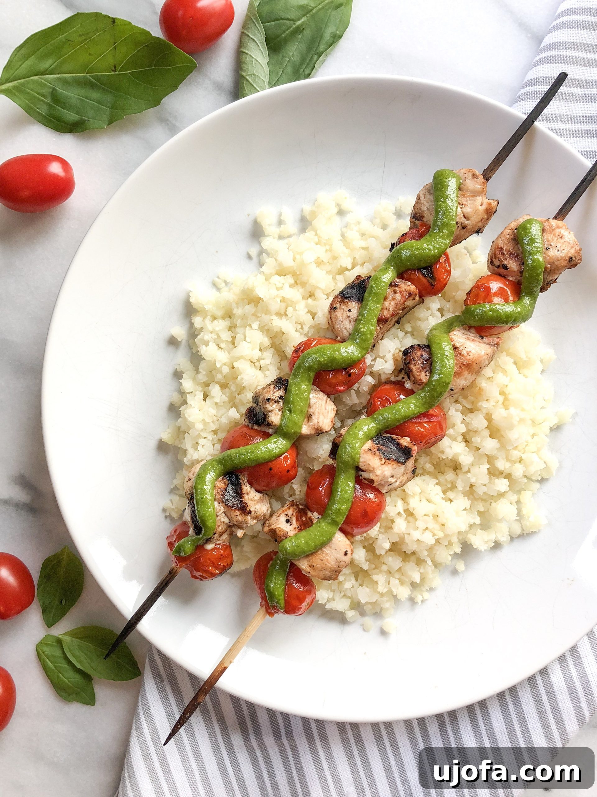 Cashew Pesto served alongside grilled chicken and fresh tomatoes on skewers (Chicken Caprese Skewers).