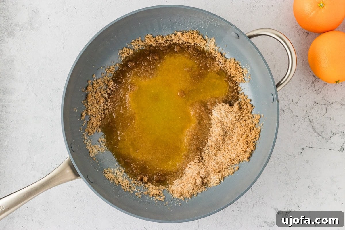 Tangy Gluten-Free Orange Chicken 13 Brown sugar and granulated sugar starting to dissolve with fresh orange juice in a pan, forming the base of the orange chicken sauce.