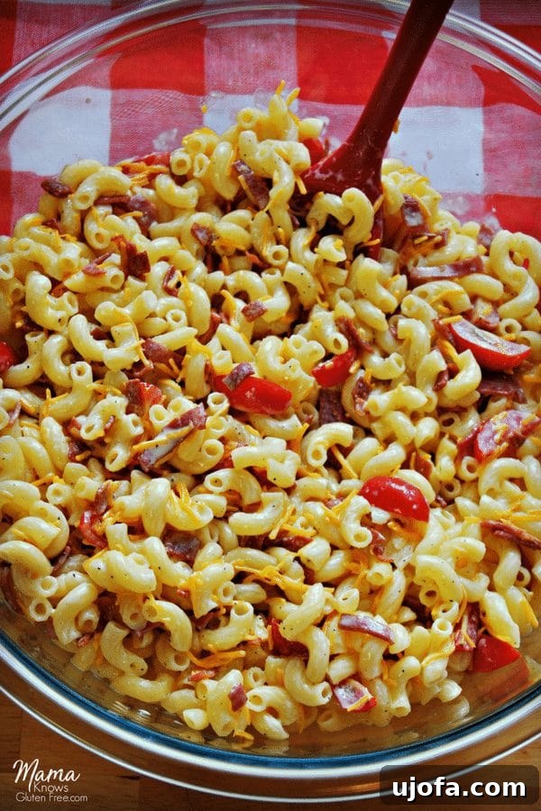 Creamy Gluten-Free Bacon, Tomato, and Cheese Macaroni Salad 2 Creamy gluten-free bacon, tomato and cheese macaroni salad in a large serving bowl, garnished with fresh herbs, ready for a potluck or barbecue.