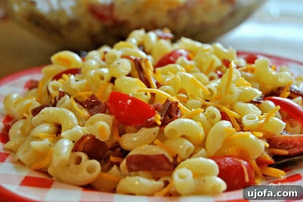 Creamy Gluten-Free Bacon, Tomato, and Cheese Macaroni Salad 3 Close-up of perfectly cooked gluten-free macaroni noodles being rinsed with cold water, a crucial step for achieving the ideal texture in macaroni salad.