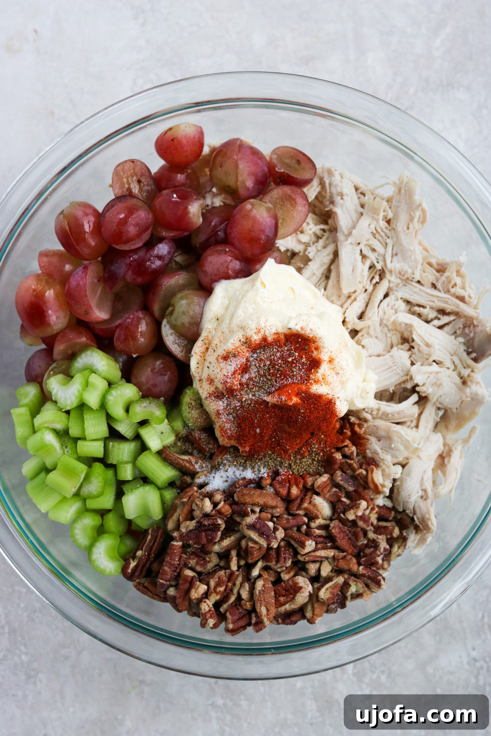 Healthy chicken salad ingredients mixed in a bowl