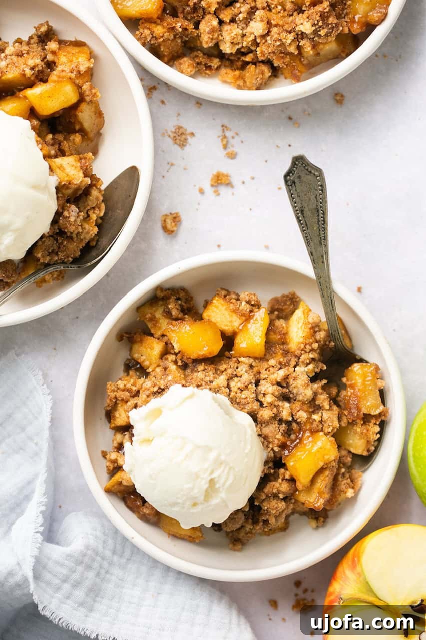Guilt-Free Apple Crumble 2 apple crumble topped with ice cream in a bowl with a spoon