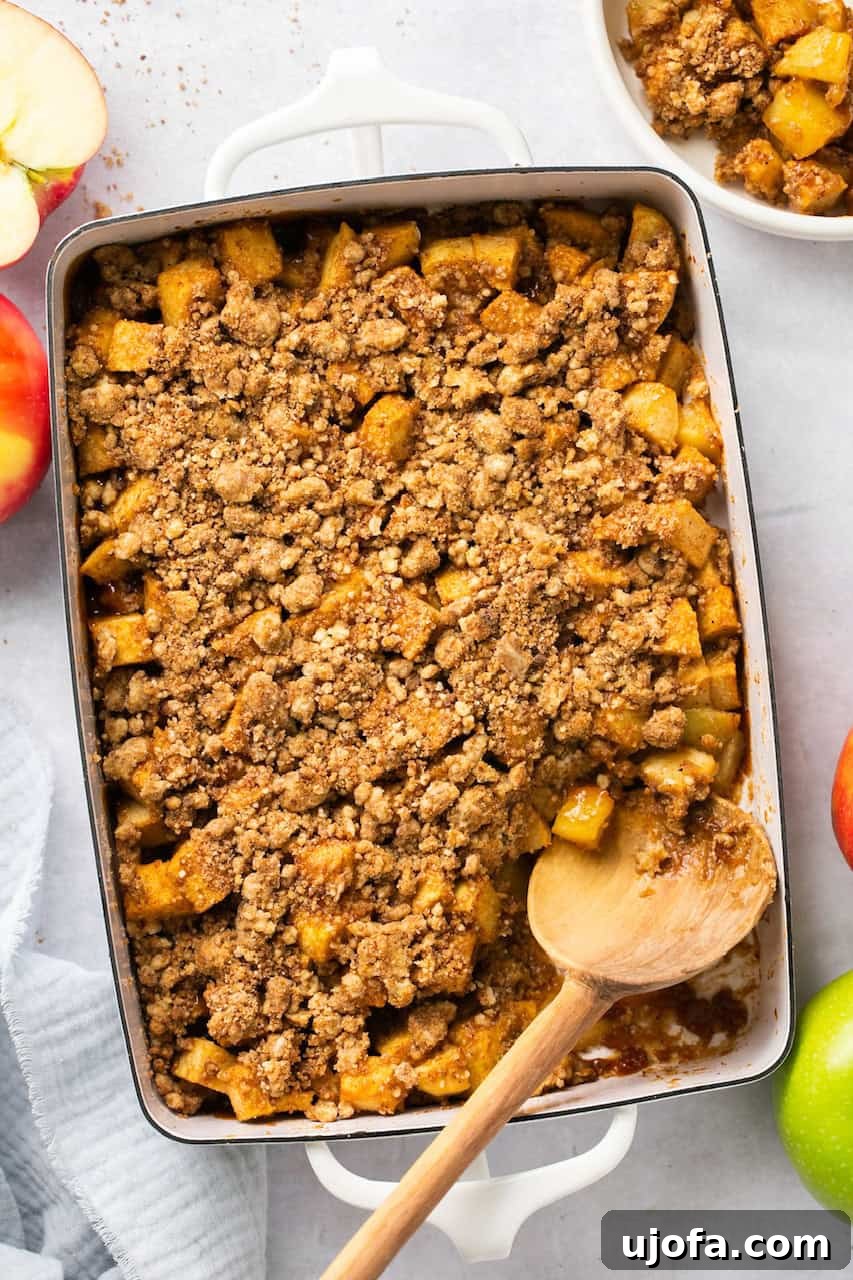Guilt-Free Apple Crumble 5 an overhead view of healthy apple crumble in a white casserole dish with a wooden spoon