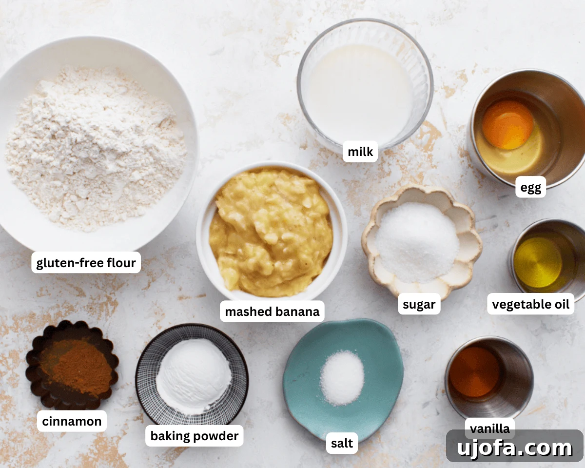 A collection of fresh ingredients neatly arranged on a countertop, including ripe bananas, a bottle of vegetable oil, a bowl of gluten-free flour, a carton of milk, eggs, sugar, and vanilla extract, ready for preparing gluten-free banana pancakes.