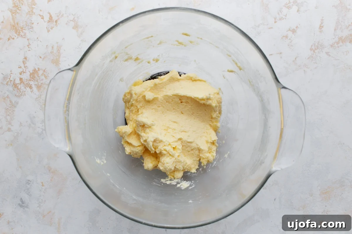 Pillowy Soft Gluten-Free Snickerdoodles 6 The smooth, creamy, pale yellow cookie batter in a glass bowl after eggs and vanilla have been perfectly incorporated, showing a consistent texture before dry ingredients are introduced.