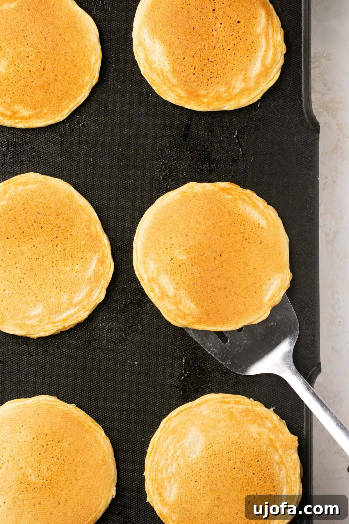 pancakes being flipped on a griddle