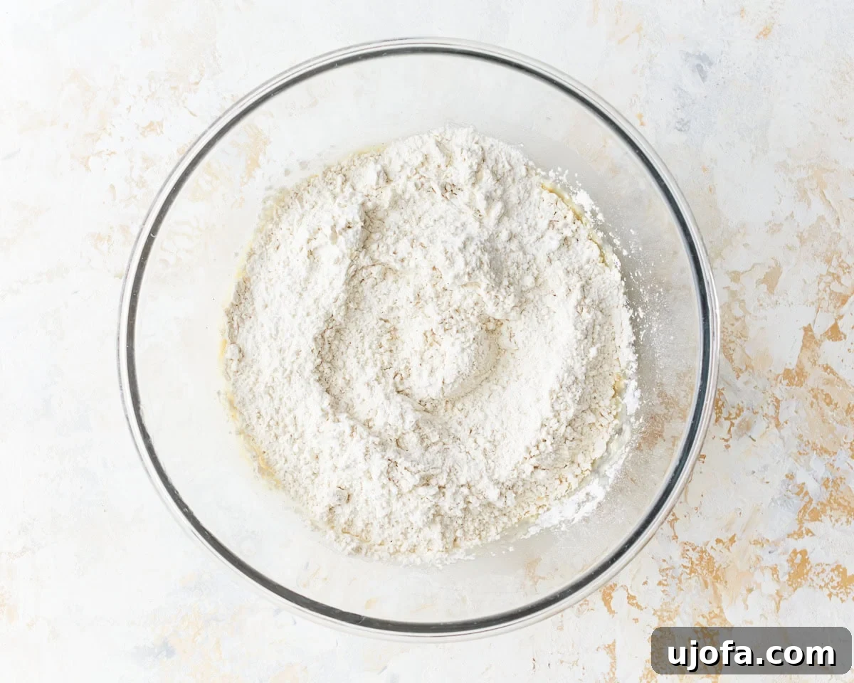 Irresistible Gluten-Free Cinnamon Buns 7 A glass bowl containing gluten-free flour, baking powder, and salt, ready to be added to the wet ingredients.