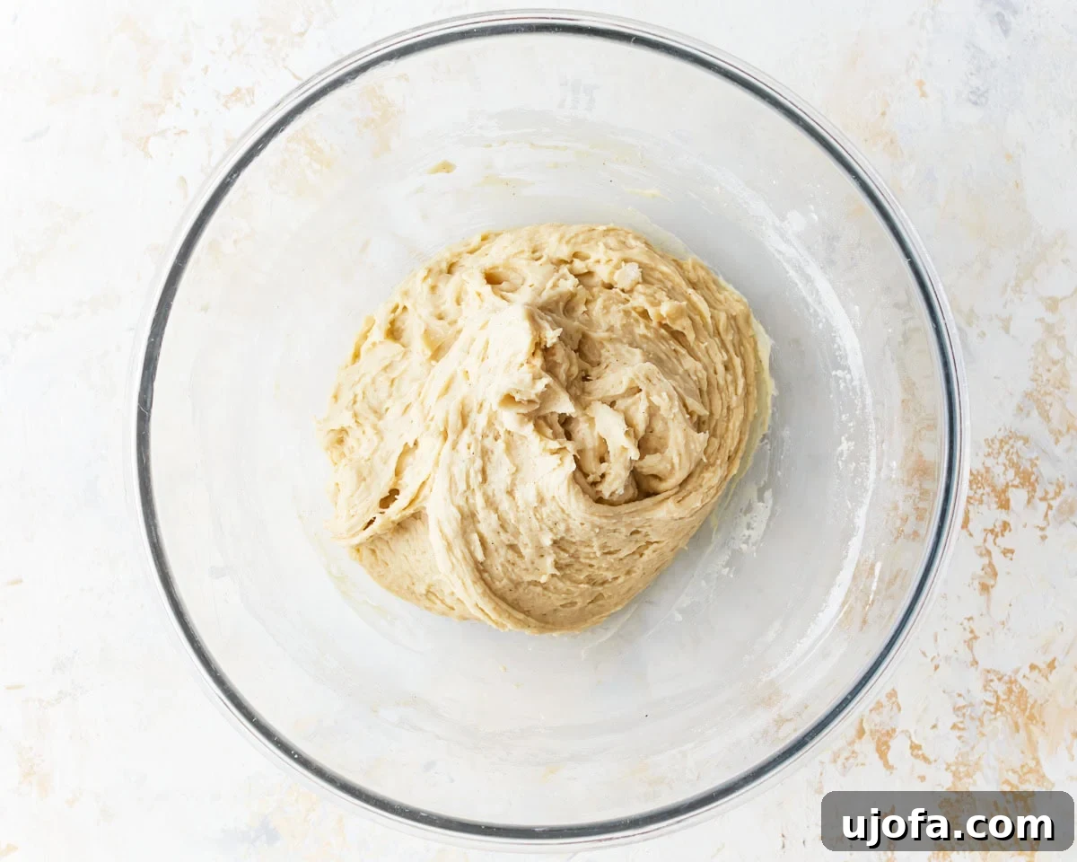 Irresistible Gluten-Free Cinnamon Buns 8 A stand mixer bowl with gluten-free dough forming, after melted butter has been incorporated.