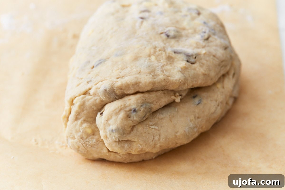 Deliciously Simple Gluten-Free Irish Soda Bread 12 The dough folded over itself on parchment paper, showing the preparation for gluten-free Irish soda bread.