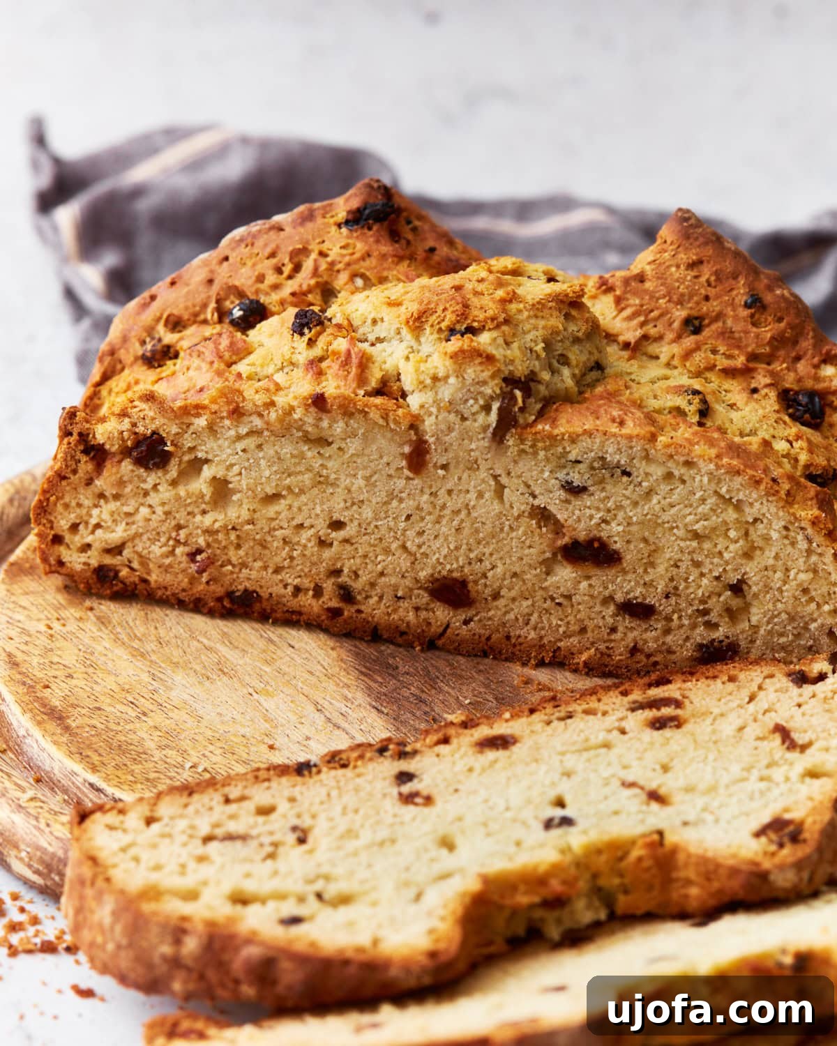 Deliciously Simple Gluten-Free Irish Soda Bread 19 Sliced gluten-free Irish soda bread, highlighting its soft crumb and raisins throughout, placed on a wooden board