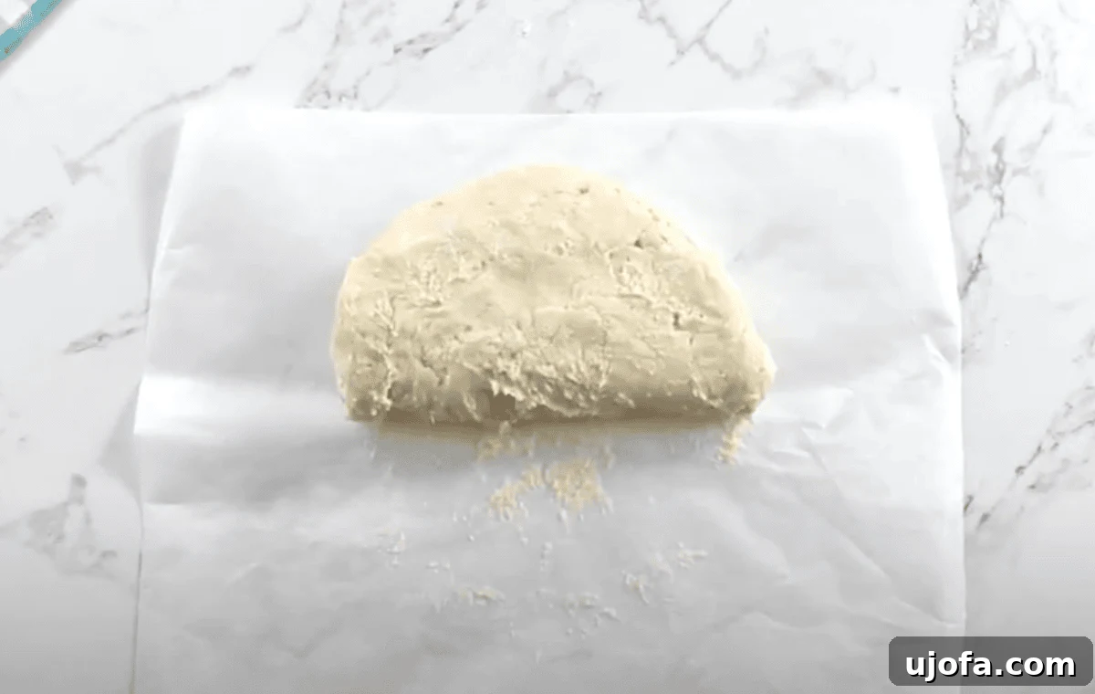 The dough is folded in half on a floured surface during the layering step.