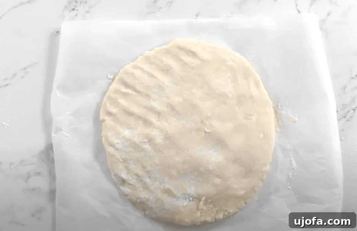 A final round of folded and flattened dough, lightly dusted with flour and ready to cut.
