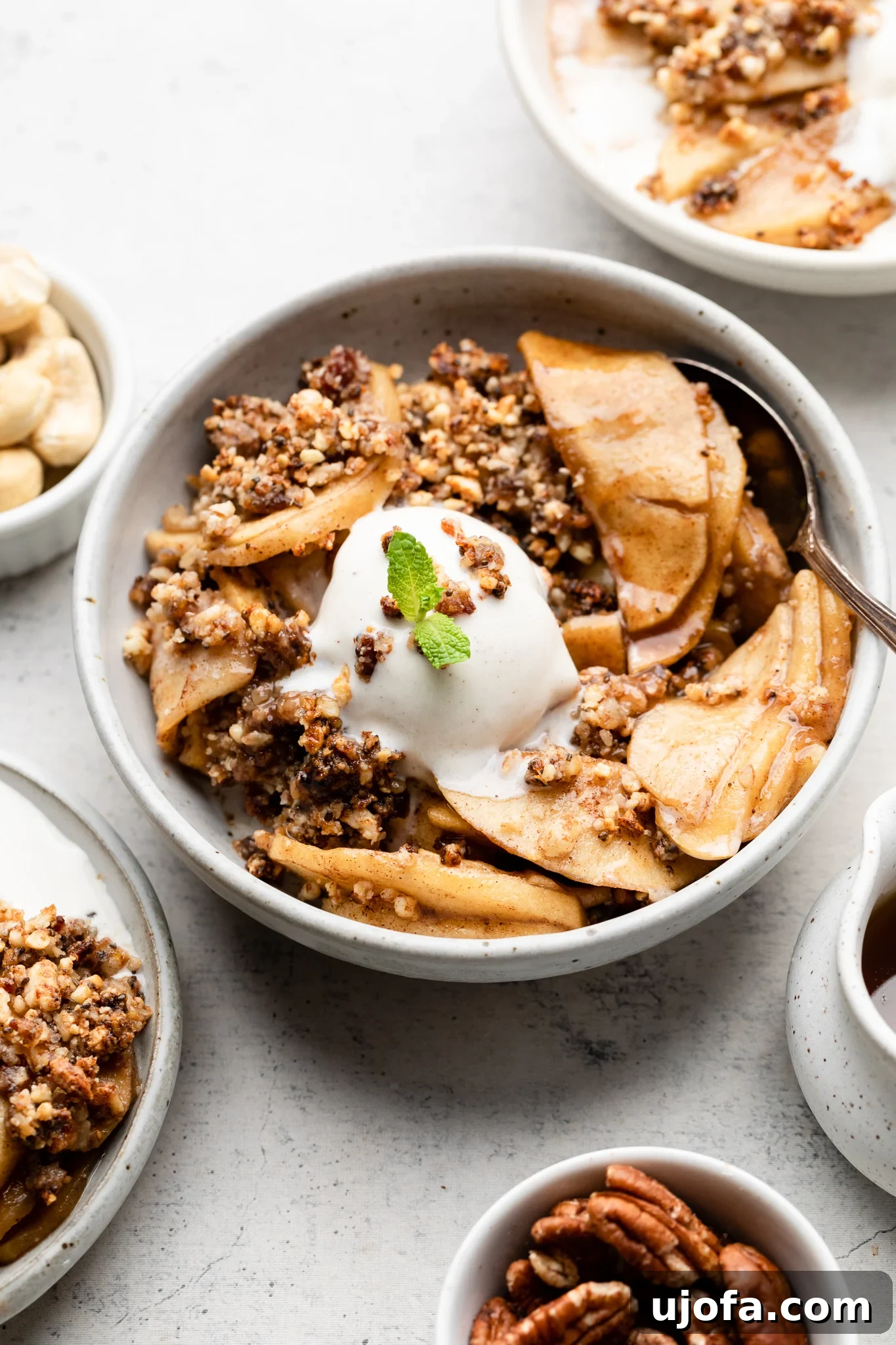 A serving of Paleo Apple Crisp with ice cream on a wooden table