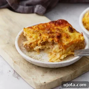 Gluten Free Brunch Delights 44 A perfectly portioned slice of gluten-free breakfast casserole, featuring savory sausage, crispy hash browns, fluffy eggs, and melted cheddar cheese, served on a small plate.