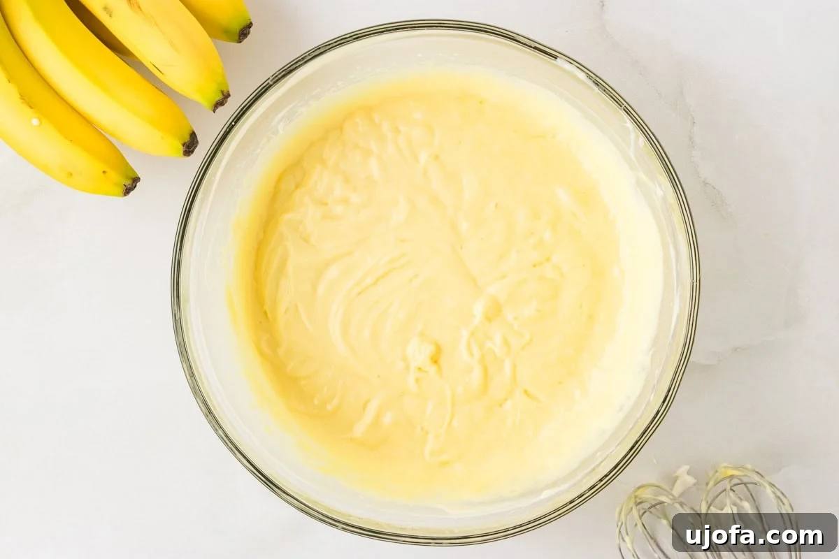 Combined pudding, cream cheese, and whipped cream mixture in a mixing bowl, with a smooth and fluffy texture.