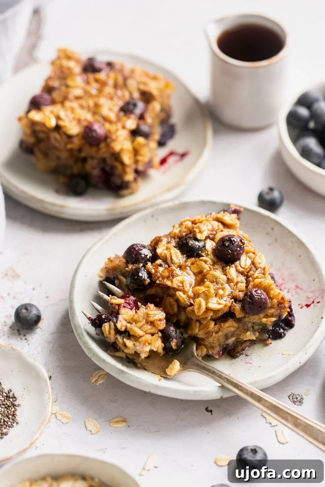A serving of vegan baked oats on a plate with a gold fork, showing a bite taken out
