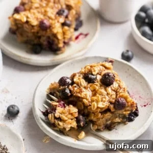 vegan baked oats on a plate with a gold fork taking a bite out