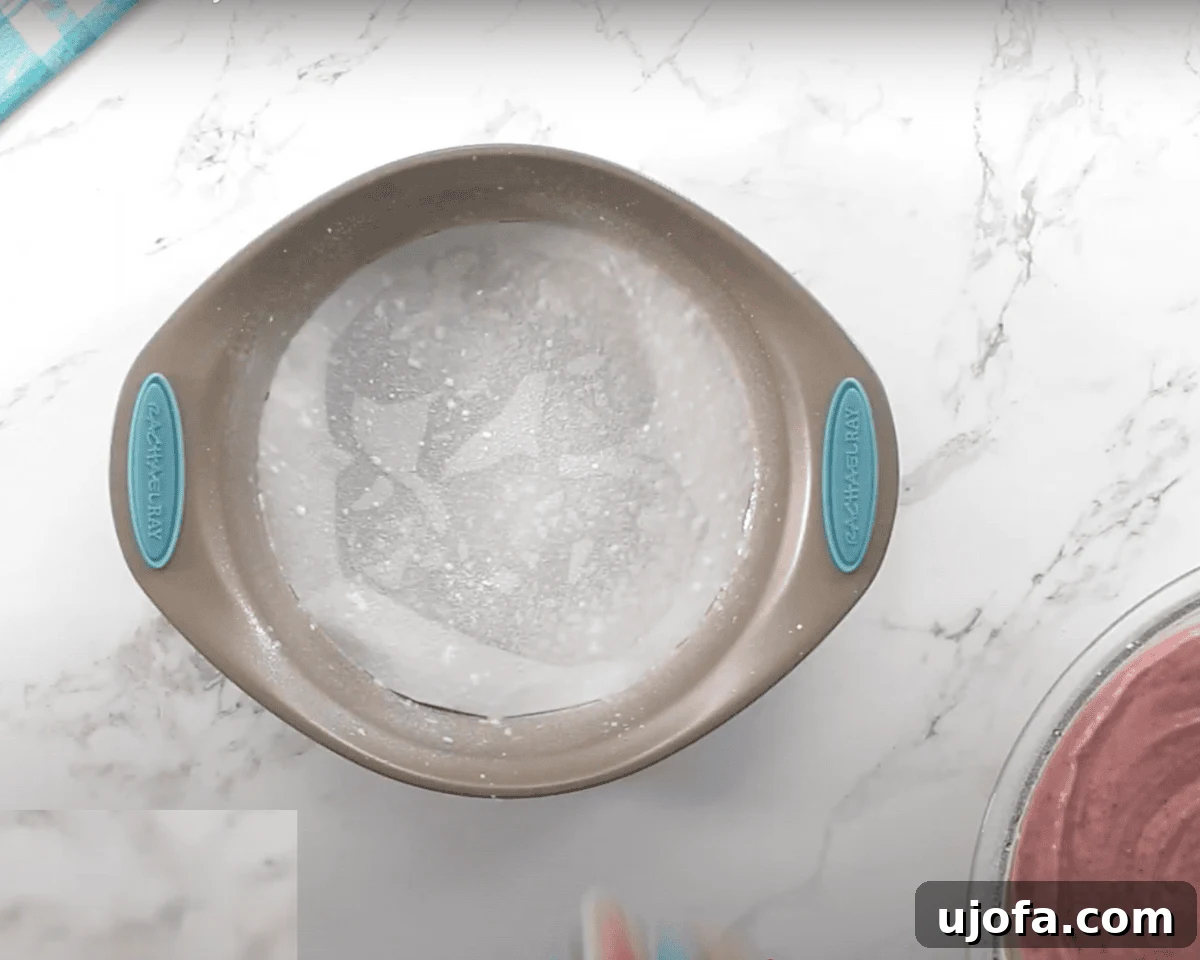 Luscious Strawberry Gluten-Free Cake 7 A round cake pan sprayed with gluten-free cooking oil spray sits on a white marble surface, ready for the batter to be poured in.