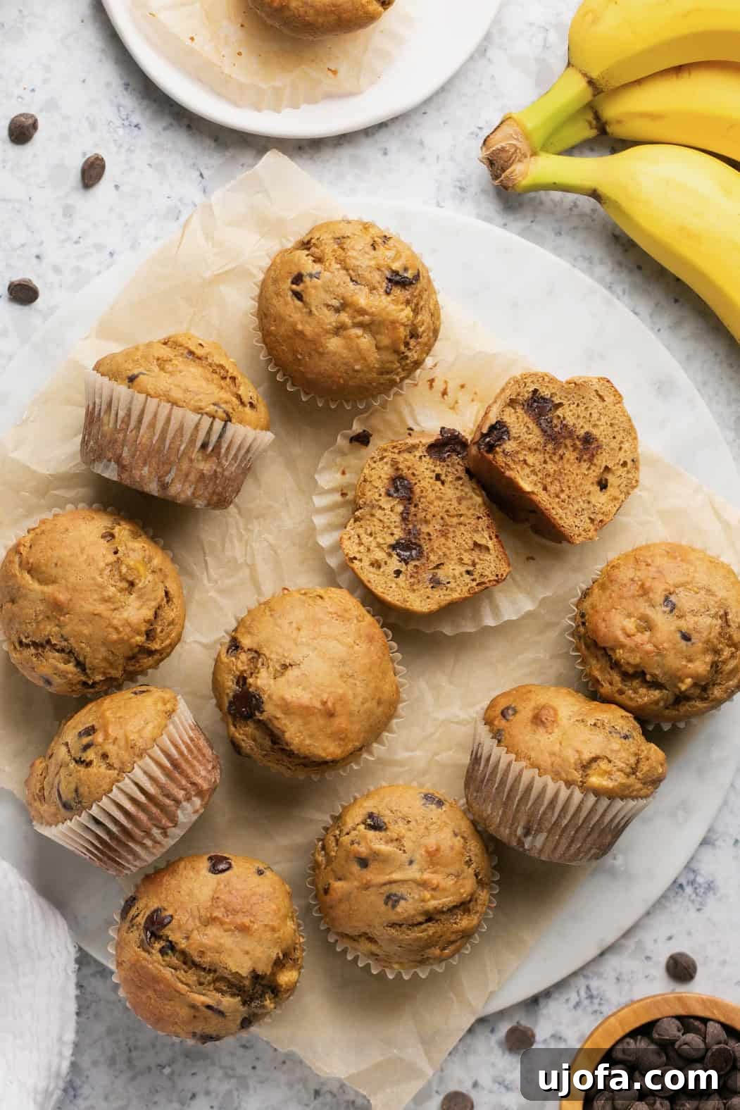 Golden-brown banana protein muffins, some with chocolate chips, arranged on a rustic lined plate, promising a healthy and delicious treat.