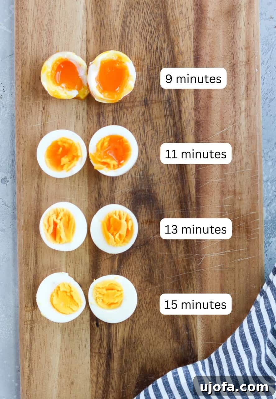 A wooden cutting board with air fried eggs sliced in half to show the cooking time for each type of egg. 