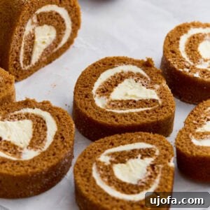 Close-up of gluten-free pumpkin roll sliced into swirls with cream cheese filling, dusted lightly with powdered sugar.