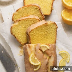 Zesty Gluten-Free Lemon Drizzle Cake 8 gluten free lemon loaf topped with lemon glaze and lemon sliced with 4 slices cut