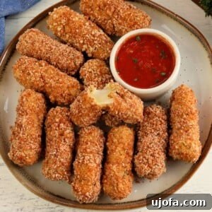 Guilt Free Mozzarella Sticks 6 gluten-free mozzarella sticks on white plate with a side of marinara sauce