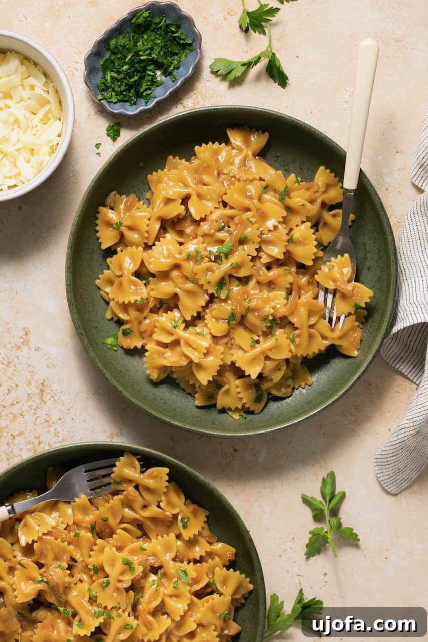 TikTok's Must-Try Gluten-Free French Onion Pasta 7 An overhead shot of a vibrant green bowl filled with gluten-free French onion pasta, with a fork resting casually on the side, inviting a taste.