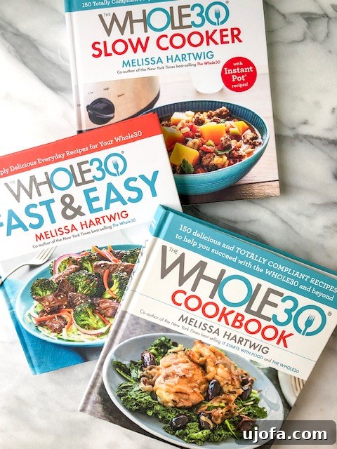 Your Whole30 Prep Playbook 3 A stack of Whole30 cookbooks, emphasizing the importance of resources.