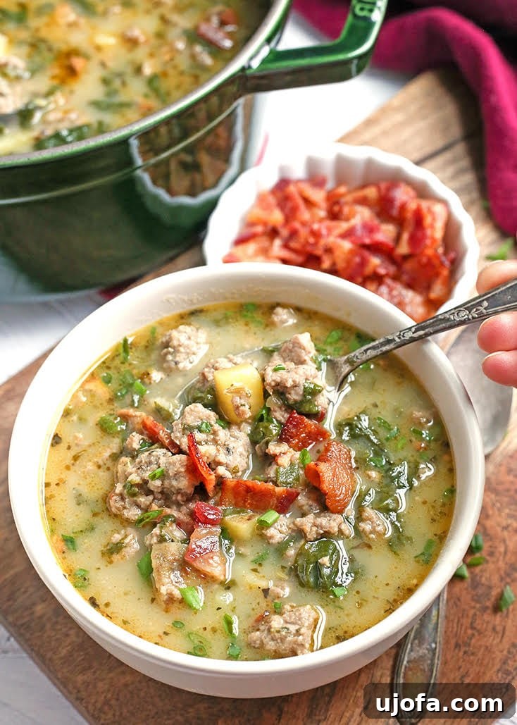 A creamy, rich bowl of Whole30 Zuppa Toscana, with sausage, kale, and sweet potato chunks.